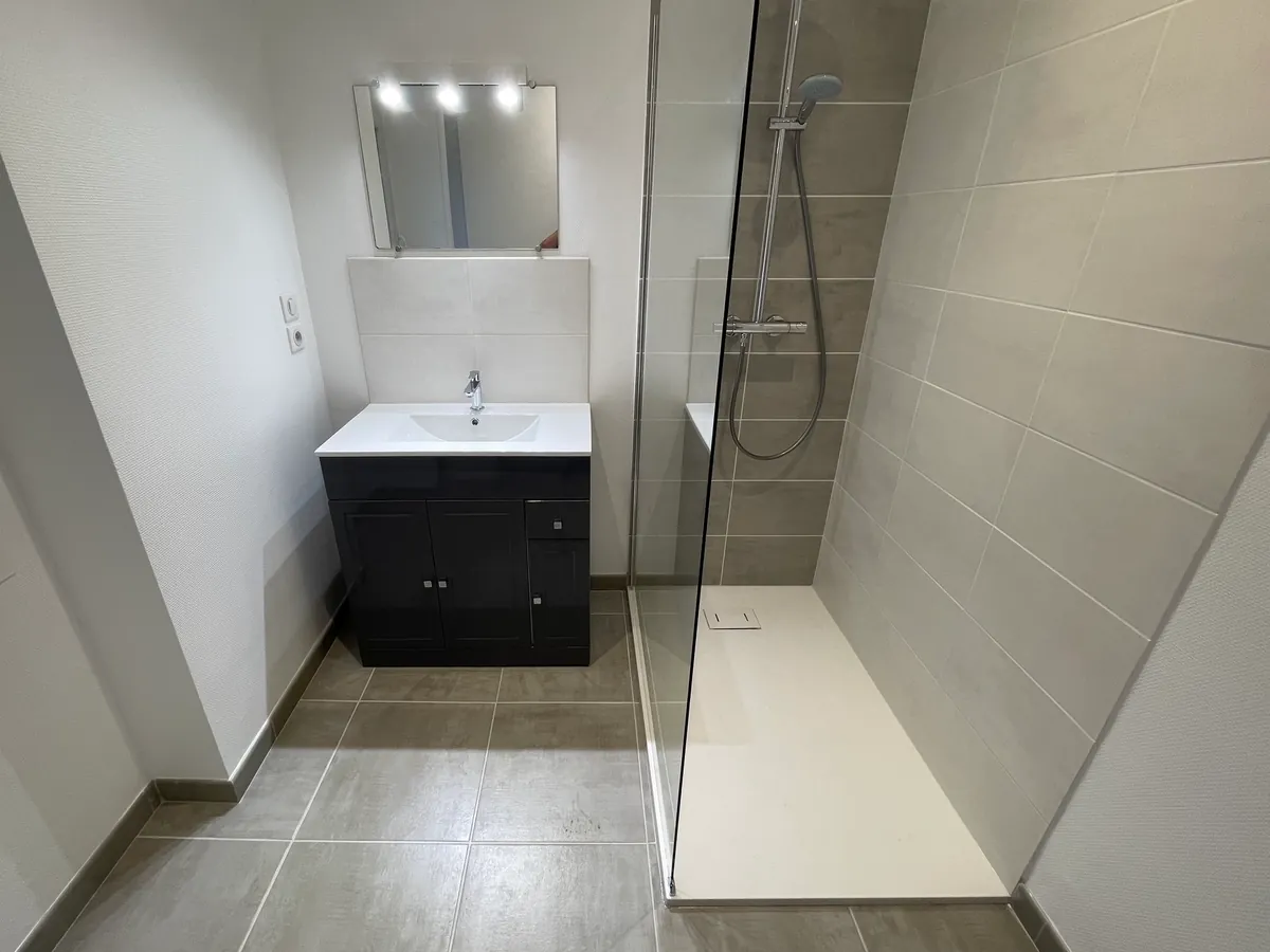 Douche avec paroi vitrée et meuble vasque sous miroir éclairé