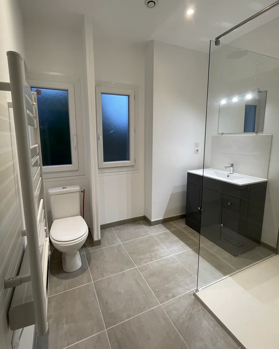 Salle de bain avec douche, WC, meuble vasque et sèche-serviettes